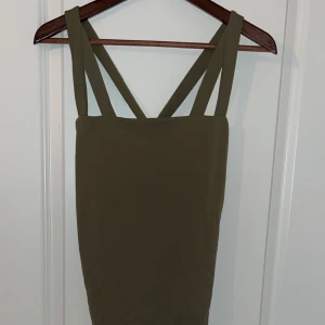 Olivgrön body - Olivgrön body i string modell från bikbok i storlek M använd någon enstaka gång.