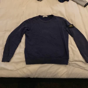 Stone Island Crewneck Mörkblå - Säljer denna Stone island tröjan i färgen mörkblå. Denna används inte av mig längre, bättre att någon med intresse för den tar över den! Inga hål osv (tvättat några gånger) så lite blekt vid kragen bättre bild av vilken färg den har i ljus ser ni på BILD3