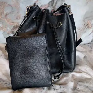 Cute black synthetic leather handbag whith cute mini bag attached to the inside that’s perfect for your wallet, makeup etc…. 