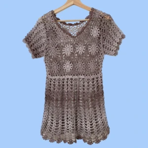 Virkad topp - Virkad topp med blommor. Eftersom den är virkad ser man igenom toppen men det syns inte så bra på bilden. Färg: vit och brun Material: 70% bomull, 30% viskos Om du har några frågor eller vill se mer bilder är det bara att skicka iväg ett meddelande:)