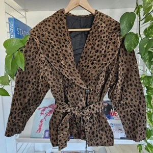 Leopardjacka - Vårjacka i leopardmönstrat tyg. Vaddering i axlarna. Det står ingen storlek på men passar mig som har 36-38.