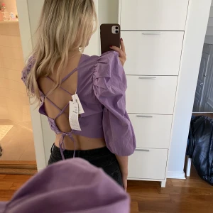 Gina tricot - Jättesöt Gina tricot blus med puffärmar. Den har så snygg snörning på baksidan. Aldrig använd med prislappar kvar!