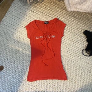 Söt topp från BEBE❤️‍🔥 - Säljer en topp från BEBE med gemstones där framme.❤️‍🔥 Jättefin färg och i bra skick. Frakt står du för själv!💕