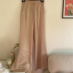 Byxor satinliknande material - Superhärliga flowy beiga byxor, jättefin passform. 