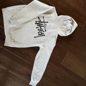 Stussy hoodie - Säljer min gråa stussy hoodie som är i fint skick och är använd ett par gånger. Skulle säga att den är liten i storlek även fast den är M. Köparen står för frakten🤍