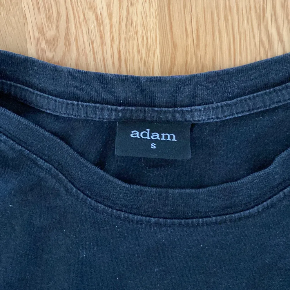 En svart T shirt ifrån märket Adam som är storlek S. Passar både killar och tjejer!. T-shirts.