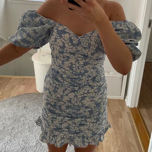 Blå blommig klänning  - Säljer min blå blommiga klänning från Gina tricot. Köpt förra sommaren och är aldrig använd. Köparen står för frakten.