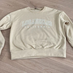 Beige sweatshirt  - Beige sweatshirt med ”los angeles california” tryck. Ganska tunt material så passar till både sommaren och vintern