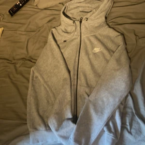 Nike Hoodie  - Nike Hoodie med zip, köpt i vintras för ca 750-800kr. Inga synliga fläckar förutom en (se sista bilden) en liten rosa fläcken som knappt syns, man lägger inte märket till den. Inget problem med den jag gillar hur den sitter har bara för många.