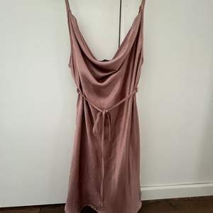 Rosa klänning med band i midjan, passar en XS-S. Använd fåtal gånger.  Frakt ingår ej i priset. 