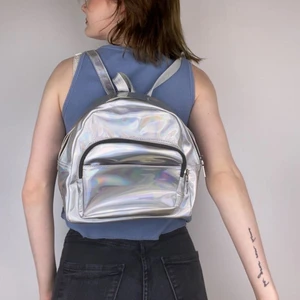 Holographic Väska - Holographisk liten ryggsäck. Jättecool och unik men använder inte längre så därför säljs den. Litet litet rött märke på men inget som syns alls.  Köpare står för frakt . Kan mötas, ta direktbetalning eller Swish💎