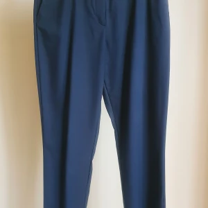 Svarta kostymbyxor fr J Lindeberg  - Kostymbyxor fr J Lindeberg, str 34. Avsmalnande ben och resår i midjan, 60% ull 40% codura, nya, pris 600 kr