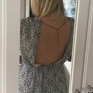 Unik klänning med öppen rygg och guldkedja från BikBok💗 Fint grått mönster och luftigt tyg. Storlek M. 