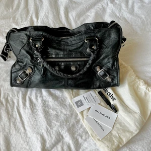 Svart äkta Balenciaga väska  - skitsnygg äkta svart Balenciaga väska! Köpt på Plick! Äkthetsbevis medföljer även från vestaire collective. Användning syns på banden men inget jag tänkt på! Skriv privat för fler bilder/mått! Kan gå ner i pris vid snabbt köp, ev byta till en mindre storl