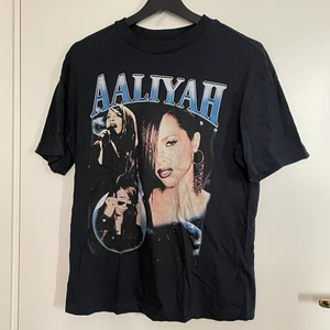 Mörkblå T-shirt med tryck - Mörkblå T-shirt med Alliyah tryck från H&M. Använd fåtal gånger. Storlek XS men väldigt oversized så passar upp till M. Köpare står för frakt :)