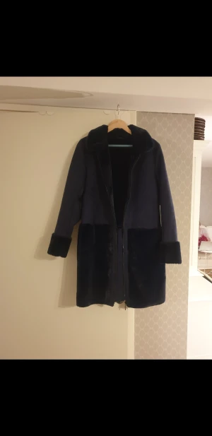 Vila kappa - Helt ny och oanvänd kappa från Vila, aldrig använts endast testat. Nypris var 1099kr   Kappa i mocka imitation & "fusk päls" Dragkedja & fickor fram. Super mysig verkligen och så mjuk på insidan då det är samma material på insidan. (päls imiterade)  