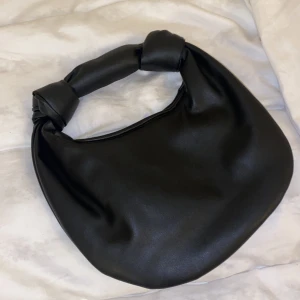 svart väska  - svart väska med knutar i sidan. använd max 3 gånger.  köpt för 300kr säljes för 120kr. pris går att diskutera 