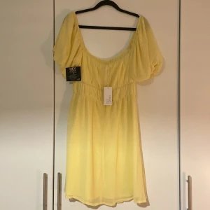 Klänning  - Super gullig citron gul klänning med puffärmar. Säljer då den aldrig kom till användning. Storlek 38.