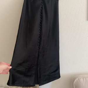 Knälång kjol - Slits framtill. I fint skick, lite slitningar längst ner på baksidan, därav priset!