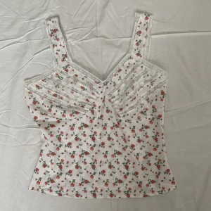 Blommig topp - Blommig topp med spetsdetaljer och dragkedja på sidan 