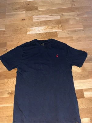 RALPH LAUREN T SHIRT (SVART) - Svart ralph lauren t shirt i toppskick, säljer den för att den har blivit för liten för mig. Storlek: 170 Nypris: 599kr Köp nu: 200 kr