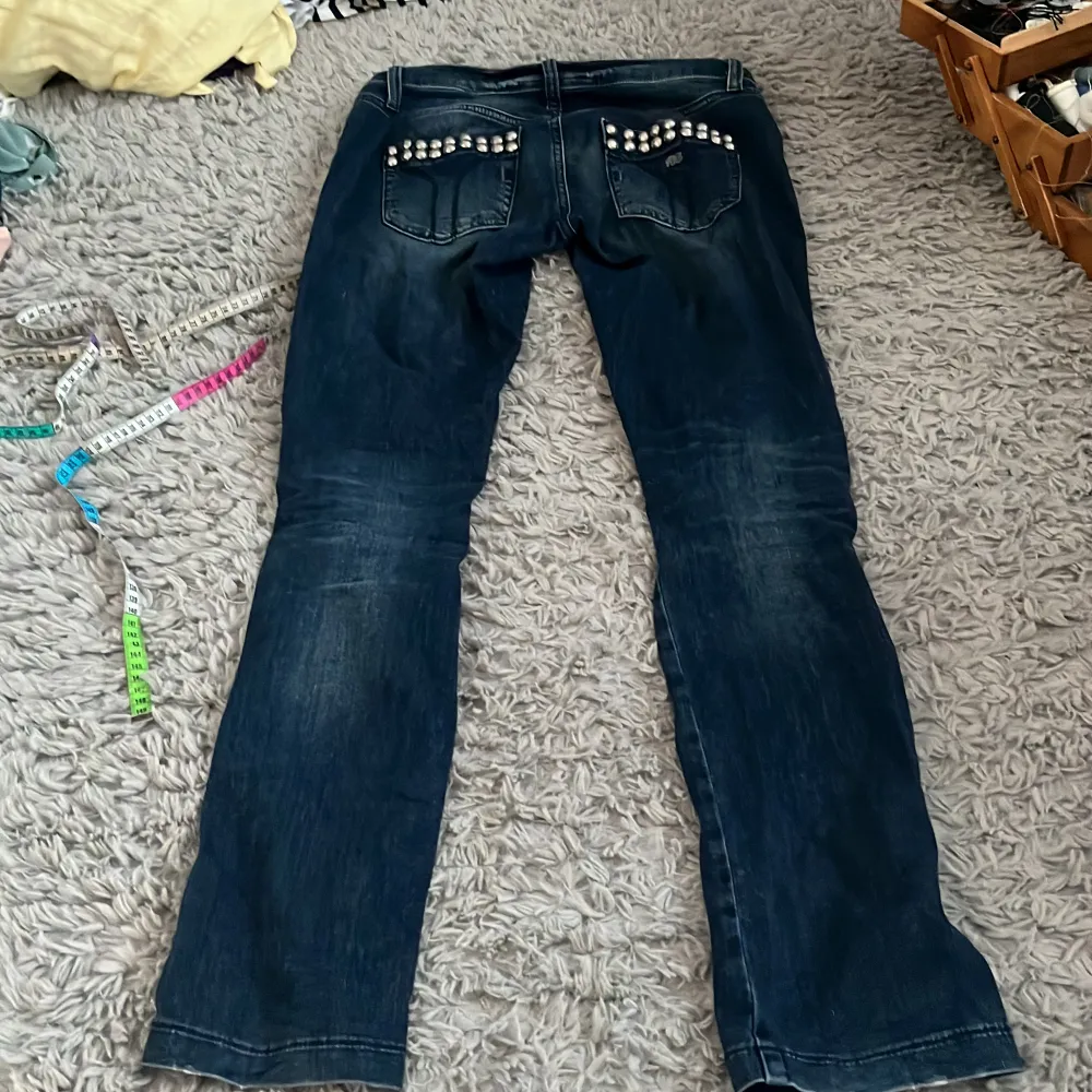 Lågmidjade superfina jeans med coola detaljer på drickorna båda fram och bak. Fint skick! 39 midjemått rakt över, 84 innerbenslängd. Jag är ca 165 som referens. Frakt är exkluderad . Jeans & Byxor.