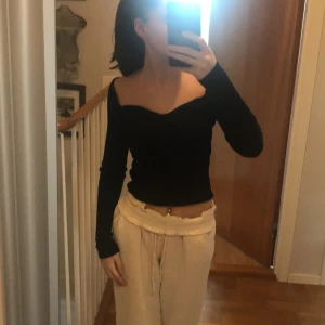 Tröja/topp - En svart topp som är lite offsoulder i storlek M men passar även S