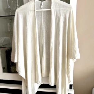 Poncho - Vit poncho som man bara lägger över axlarna 