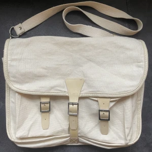 Snyggaste väskan - Säljer denna beiga väskan i linnetyg med två stycken fickor fram. Bandet går att justera och man kan ha väskan både korsad och på axeln. Inuti har den två olika stora fack. Rymmer mycket😋
