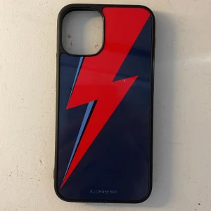 David Bowie skal - Säljer detta skal som har David Bowie-blixten som motiv, den har en liten vit plupp på sig, men det är ingenting som påverkar funktionen eller så ❤️jag råkade beställa två stycken, därför säljer jag det ena ☺️Jag har en iPhone 12 mini!