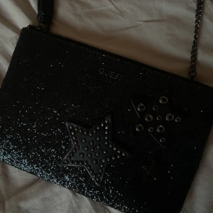 Guess väska - Glittrig axelremsväska med stjärnor från Guess❤️‍🔥
