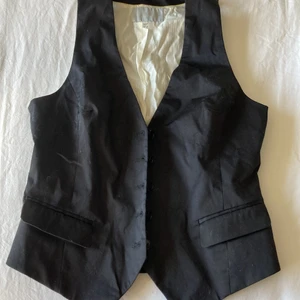 Kavaj väst - Otroligt cool kavaj väst med v neck som också har en otroligt cool detalj på baksidan! Från hm! Frakt ingår inte i priset och kan mötas upp i Stockholm :) (köparen står för frakt) Använd ett fåtal gånger men inga defekter. (Står inte för postens slarv)
