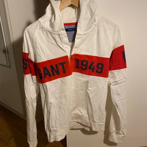 Ganthoodie med knappar, vit och röd  - Ganthoodie, vit och röd med knappar. I mkt gott skick dock skrynklig då den legat längst in i garderoben. Storlek S i herrstorlek. 