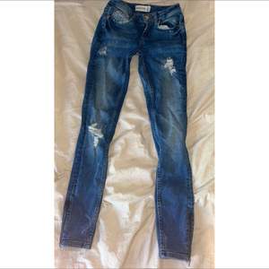 Mörkblå slitna jeans