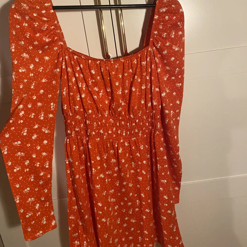Långärmad röd/orange somrig klänning från H&M, använd en gång, nypris 249kr. Går att ha både off shoulder och med lite piffigare axlar. Frakt tillkommer!!!. Klänningar.