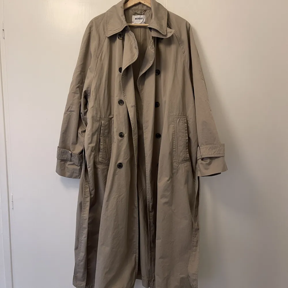 Beige trenchcoat från weekday i storlek S. Modellen på jackar heter ”travis oversized trenchcoat”. Använd 2 gånger, skicket är som nytt! Jackan är ljusare än vad den ser ut på min bilder. Nypris 1400 kr.. Jackor.