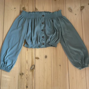 Blus off-shoulder i grön blå  - En grön/blå blus från HM i storlek XS, aldrig använd så skicket är som nytt! 
