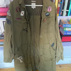 Tunn kappa - Tunn kappa med tryckta stickers. Perfekt till sommaren. Obs flöckar på ryggen jag inte vet om dom går bort. 