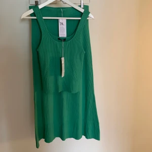 Kjol & linne från Gina Tricot - Ett ribbat set med kjol och linne från Gina Tricot i en härlig grön färg 😍helt oanvänt med lapparna kvar, perfekt till vår och sommar! Linnet är i storlek L och kjolen i M. 