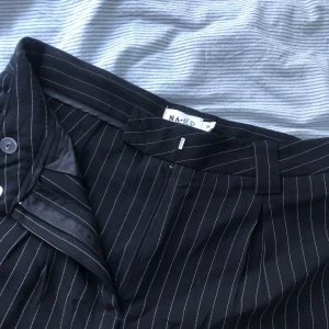 Kostymbyxor - Svarta kostymbyxor med ränder! Jättebekväma och snygga men kommer tyvär inte till användning😅Jag är 175 och det är bra längd i benen!