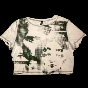 Graphic croptop - En benvit med grönt tryck babytee/croptop med tryck. Från h&m, endast använd en gång så den är som i nyskick. Sitter bra på mig som brukar ha S :) tveka inte på att höra av er vid frågor! *TRYCK INTE KÖP NU*