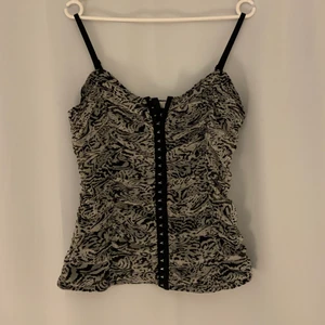 Refflig korsett-aktig topp - Superfin topp som ser ut lite som en korsett. Materialet är dock nästan lika tunt som ett vanligt linne. Man kan knäppa den hur man vill🥰