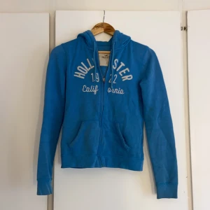 Tröja - Blå luvtröja från Hollister i storlek S. 