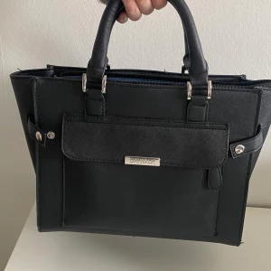 väska i märket catwalk - 💜En svart väska som är perfekt till det mesta, den har 2 innerfickor och ett innerfack med dragkedja samt ett på utsidan Priset kan diskuteras