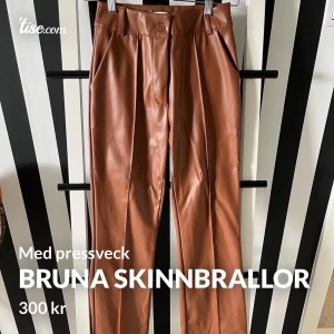 Bruna skinnbrallor med pressveck  - Aldrig använda. Storl S