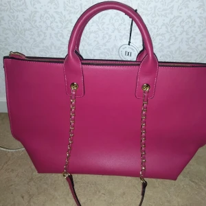 Rosa DonDonna Väska - Helt ny oanvänd Don Donna väska. Den har mycket utrymme och är effektiv. Den har axelband och handtag. (Den är dock lite mörkare i verkligheten)