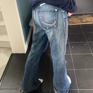 Säljer ett par lågmidjade jeans med tryck på baksidan. Jeansen är bootcut modell ish. Frakt tillkommer och paketpris gäller!