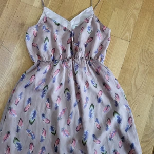 DryLake klänning  - Kort sommarklänning i 2 lager tyg. Använd 3 tal ggr. Fint skick inga hål, fläckar osv.  Storlek M/38 Färg Smuttsrosa med fjädrar