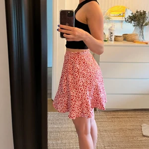 Blommig kjol - Säljer en blommig volangkjol då den inte riktigt är min stil. Fick den av min kusin och den är knappt använd. Den är justerbar vilket göra att den passar både XS-M