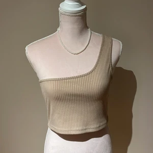 Beiget linne - Ett super fint enkelt beiget linne som är enarmad! Aldrig använt! 